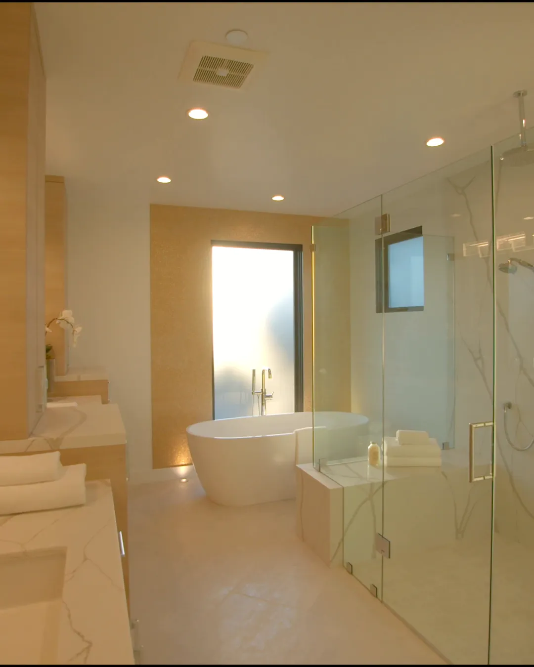 Badezimmer mit freistehender Wanne, Holzfronten und Tageslicht durch Milchglas